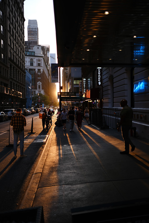 Warm evening light falling across a city sidewalk