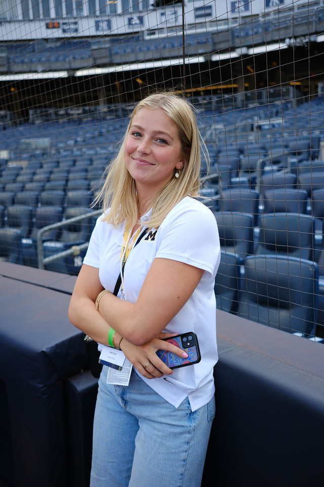 A woman smiling in the seating area of a baseball stadium